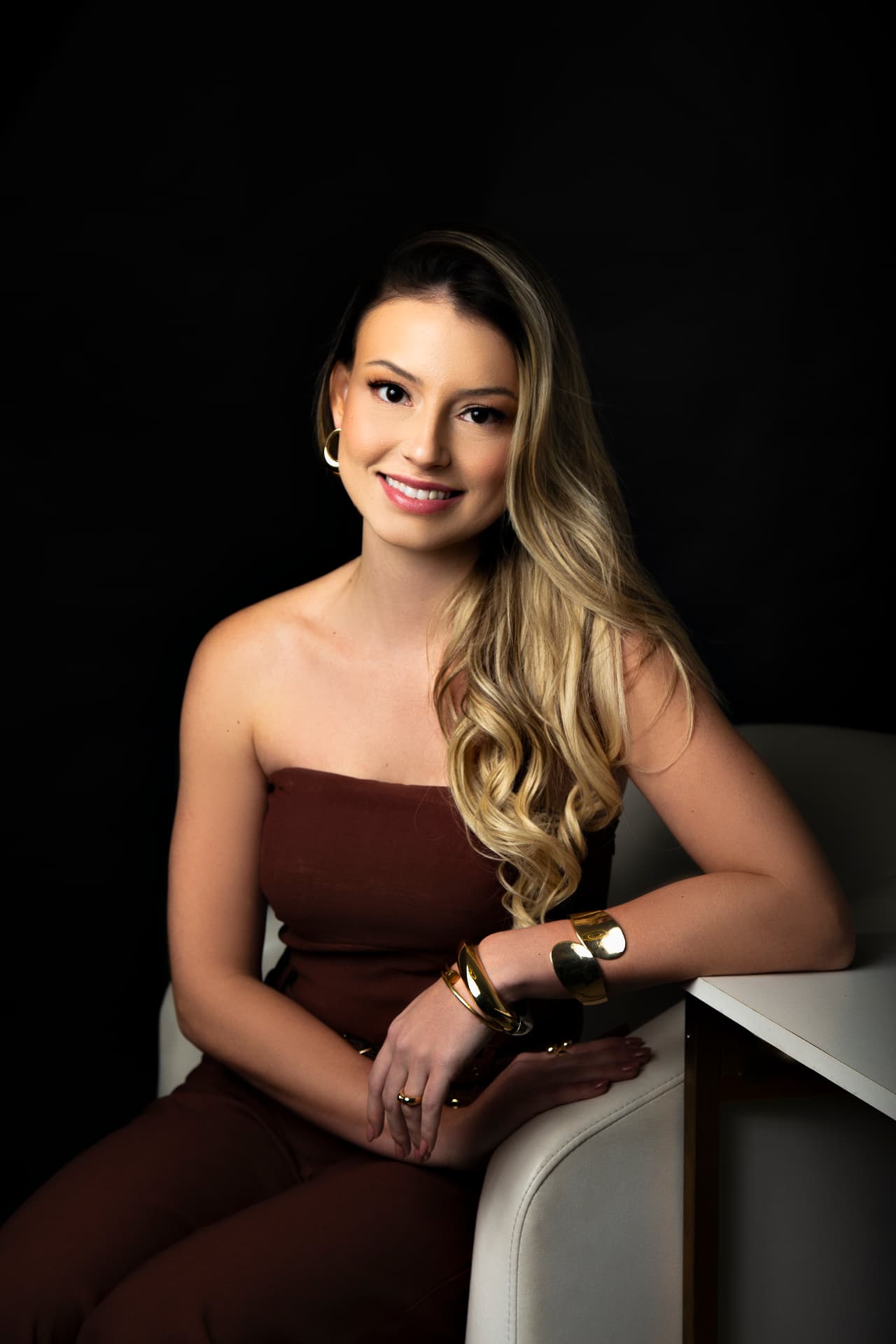 Dra. Milena Castro sentada e sorrindo, acolhendo quem chega